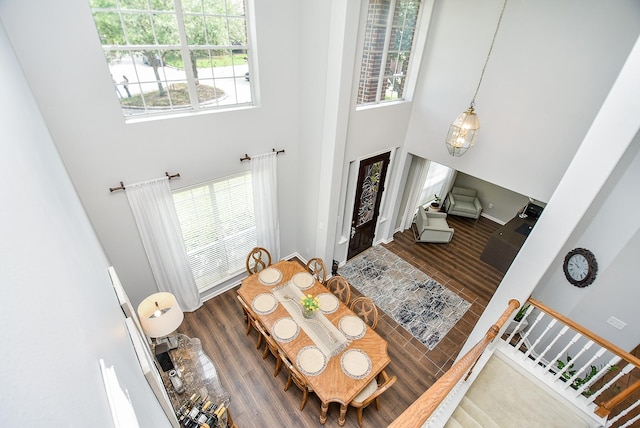 entrance foyer with stairs, a healthy amount of sunlight, a high ceiling, and wood finished floors