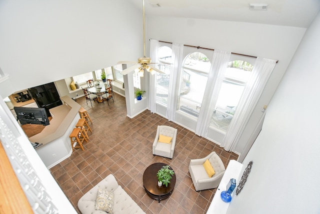 living area with lofted ceiling, visible vents, and ceiling fan