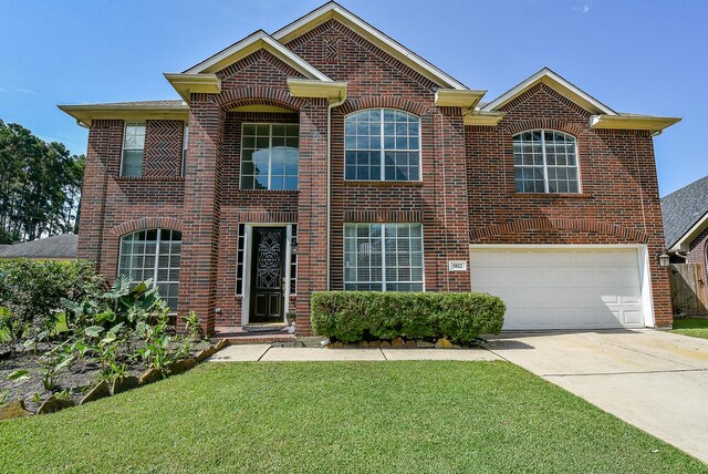 view of front of property featuring a garage and a front lawn