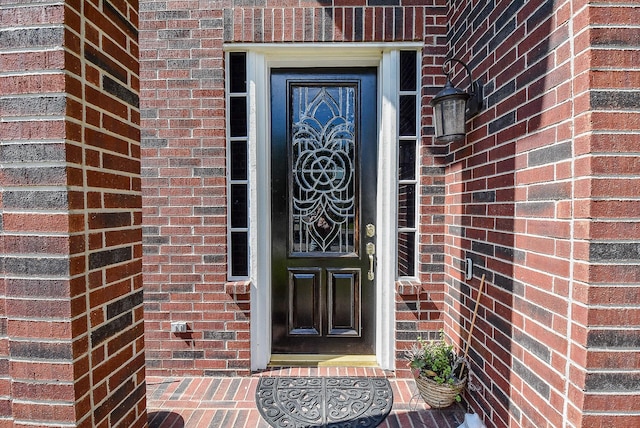 doorway to property with brick siding