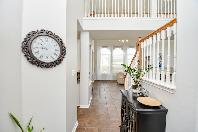 entryway featuring stairs, a high ceiling, and baseboards