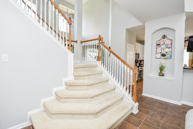 stairway featuring plenty of natural light and baseboards