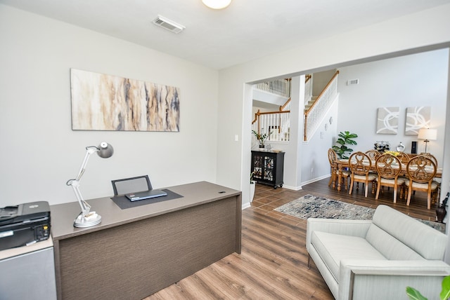 home office featuring visible vents, baseboards, and wood finished floors