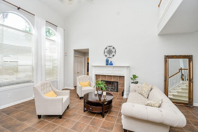 living room with high vaulted ceiling, a fireplace, and baseboards