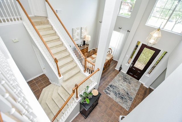 foyer featuring stairs, a high ceiling, visible vents, and baseboards