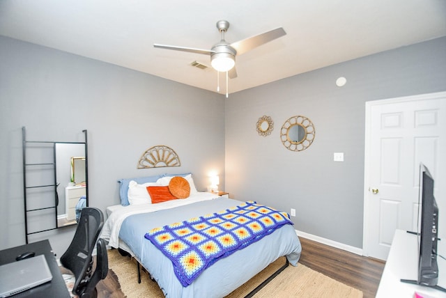 bedroom featuring a ceiling fan, visible vents, baseboards, and wood finished floors