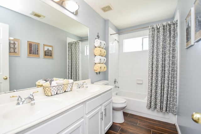 bathroom featuring wood tiled floor, visible vents, a sink, and toilet