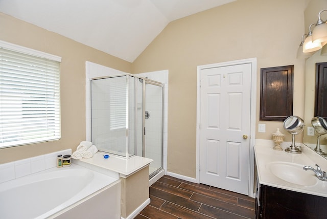 full bath with a garden tub, vanity, vaulted ceiling, a shower stall, and wood tiled floor