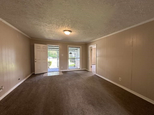 unfurnished room featuring a textured ceiling, dark colored carpet, and wooden walls