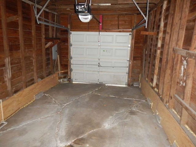 garage with electric panel and a garage door opener