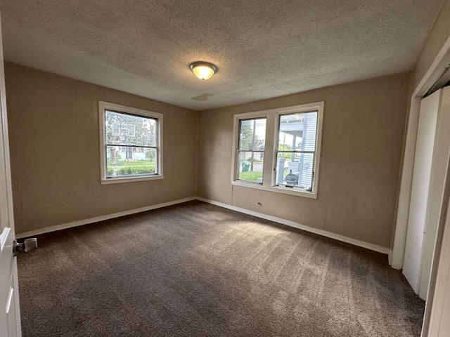 carpeted empty room featuring a textured ceiling