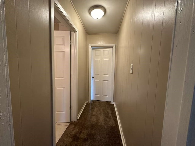 hallway featuring wood walls and light colored carpet