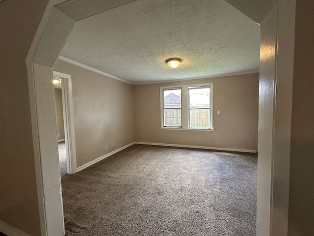 spare room featuring ornamental molding, a textured ceiling, and carpet floors