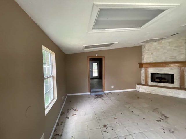 unfurnished living room with light tile patterned flooring, vaulted ceiling, and a fireplace