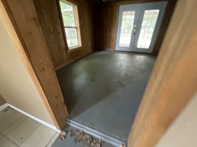 unfurnished room featuring concrete flooring, french doors, and a healthy amount of sunlight