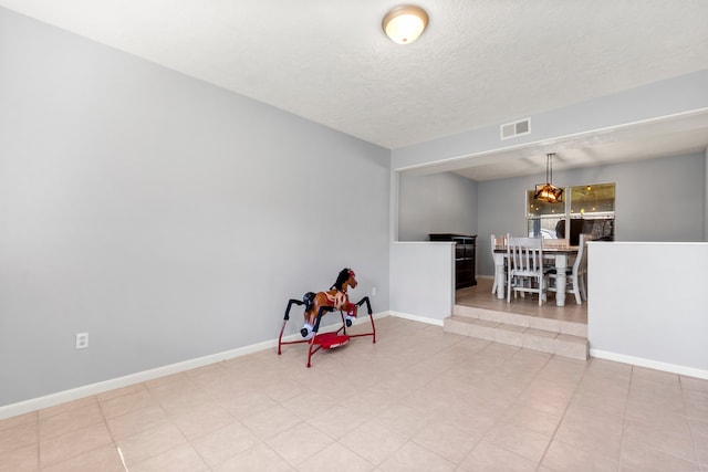 game room featuring baseboards, visible vents, and a textured ceiling