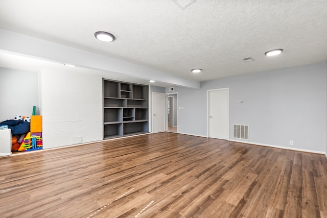 basement featuring a textured ceiling and hardwood / wood-style flooring