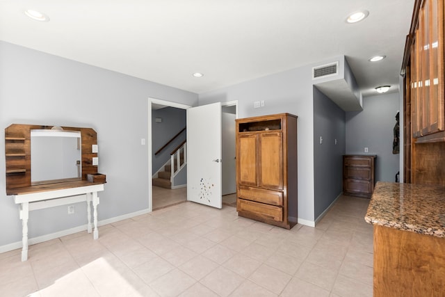 interior space with recessed lighting, visible vents, baseboards, dark stone counters, and brown cabinetry