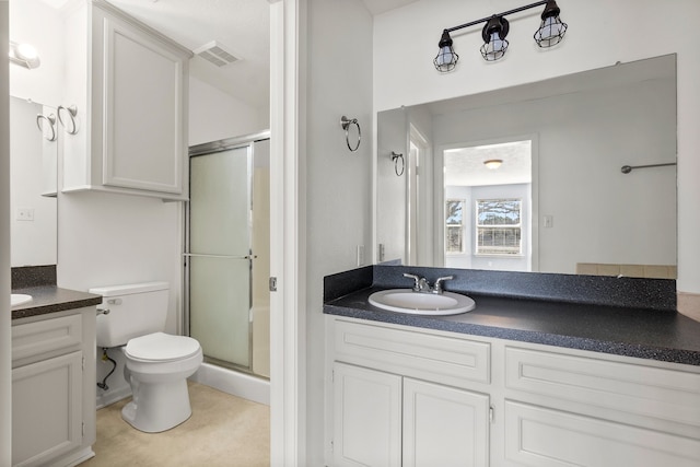 bathroom featuring a stall shower, visible vents, vanity, and toilet