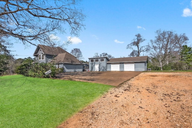 view of front of property with a front yard, a garage, and an outdoor structure