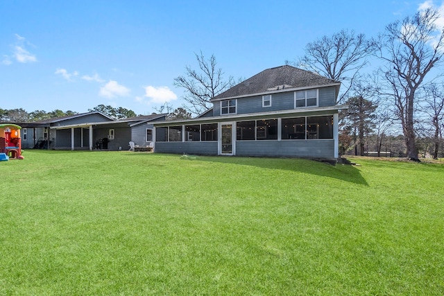 rear view of property featuring a yard and a sunroom