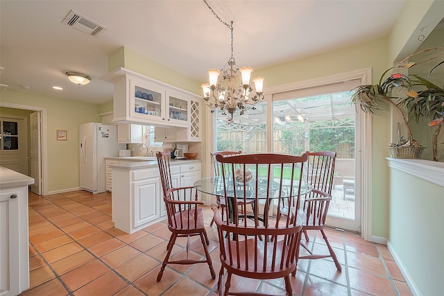 tiled dining space with sink and an inviting chandelier