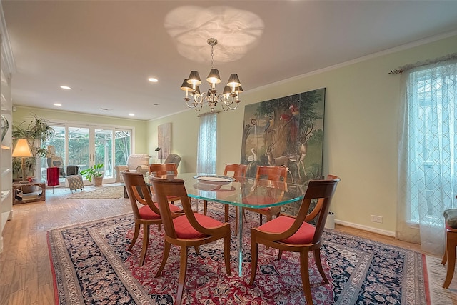 dining area with light hardwood / wood-style flooring, a notable chandelier, and ornamental molding