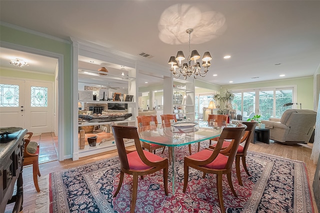 dining room featuring light wood-type flooring, crown molding, and a chandelier