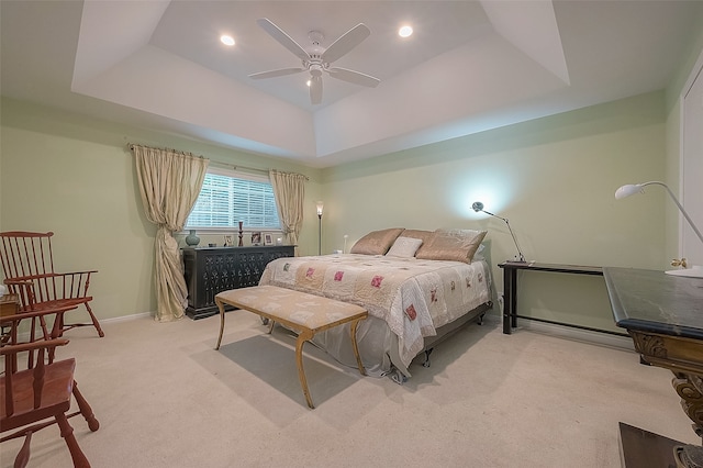 bedroom featuring a tray ceiling, ceiling fan, and light colored carpet