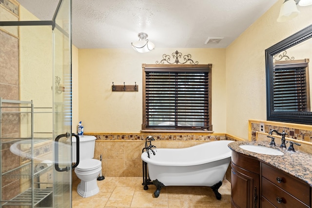 full bathroom featuring independent shower and bath, toilet, vanity, tile walls, and tile patterned floors