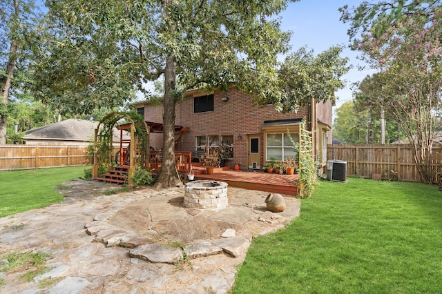 rear view of house featuring a patio, an outdoor fire pit, a deck, and a yard