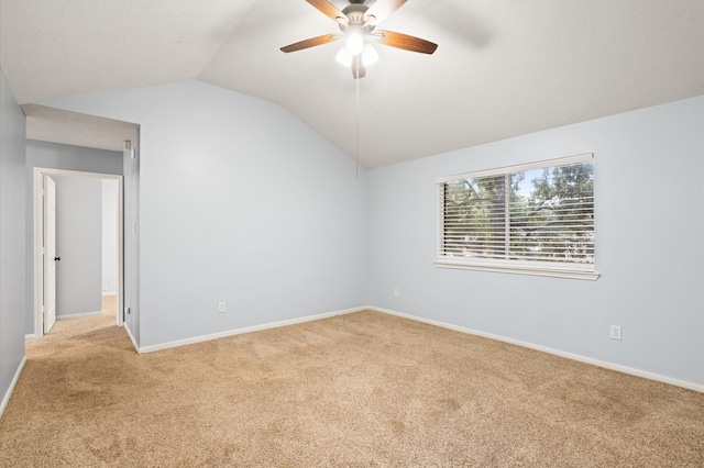 unfurnished room featuring ceiling fan, vaulted ceiling, and light carpet