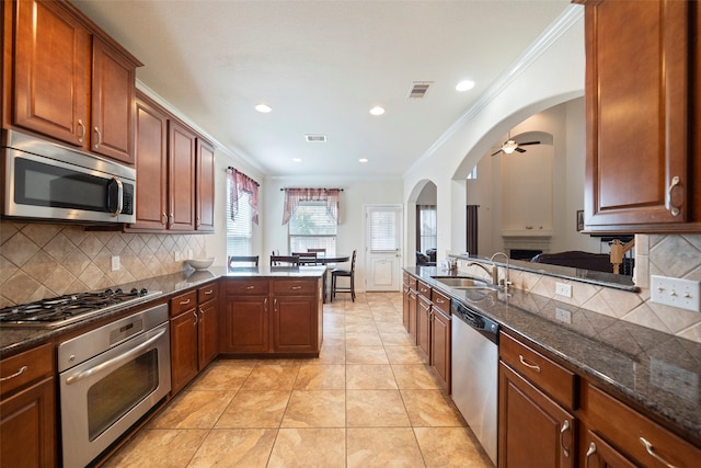 kitchen with ceiling fan, tasteful backsplash, crown molding, light tile patterned flooring, and stainless steel appliances