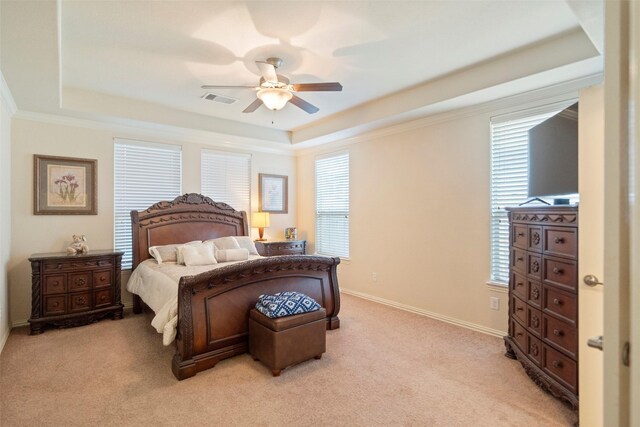 bedroom with a tray ceiling, ceiling fan, ornamental molding, and light colored carpet