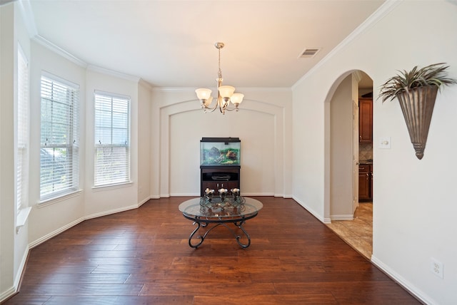 unfurnished dining area featuring a notable chandelier, ornamental molding, and hardwood / wood-style flooring