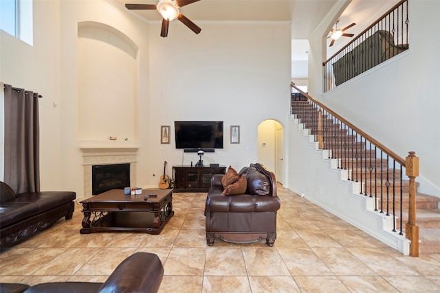 living room featuring ceiling fan, a high ceiling, and light tile patterned flooring