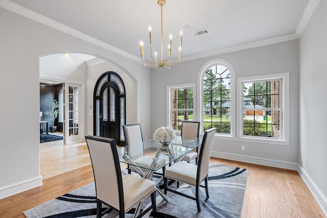 dining room featuring ornamental molding, light hardwood / wood-style flooring, and a chandelier