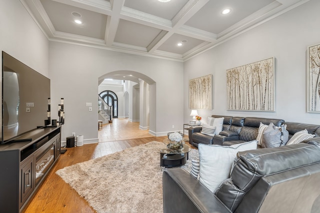 living room featuring coffered ceiling, ornamental molding, beamed ceiling, and hardwood / wood-style floors