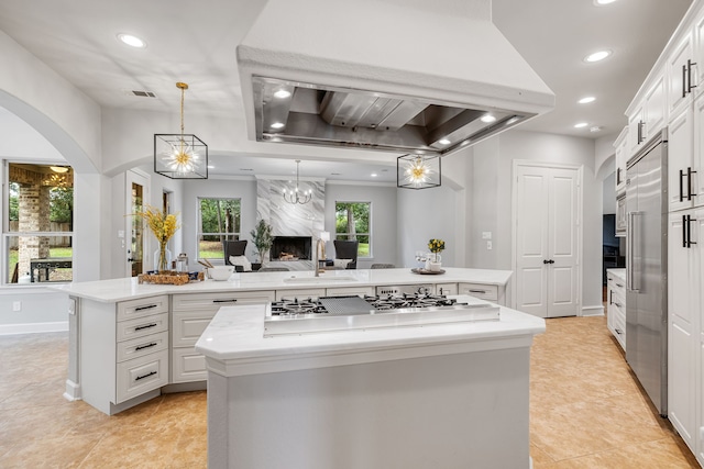 kitchen featuring white cabinets, island exhaust hood, a kitchen island, and sink