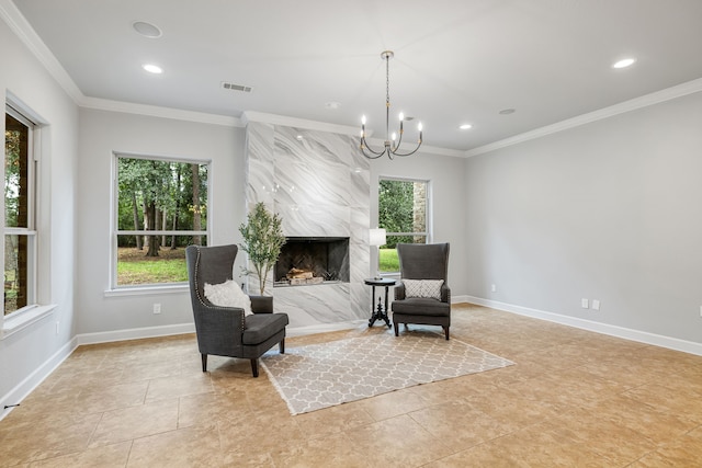 sitting room featuring an inviting chandelier, a premium fireplace, plenty of natural light, and crown molding