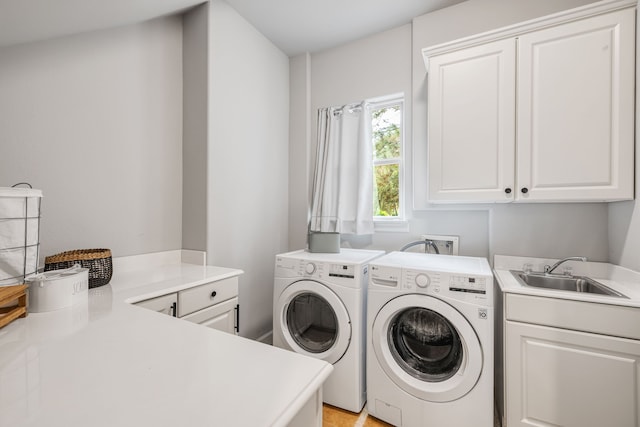 laundry room with washing machine and dryer, sink, and cabinets