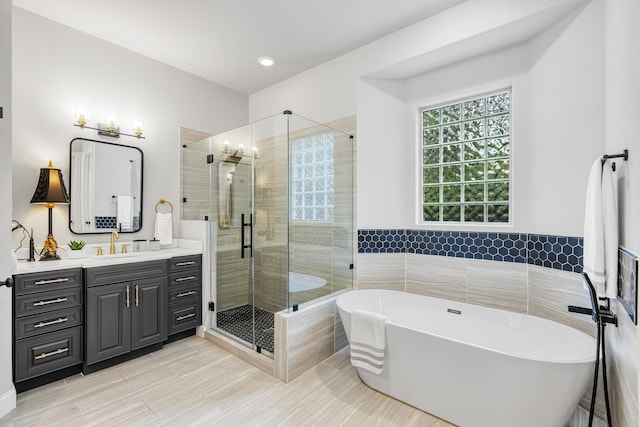 bathroom with vanity and separate shower and tub