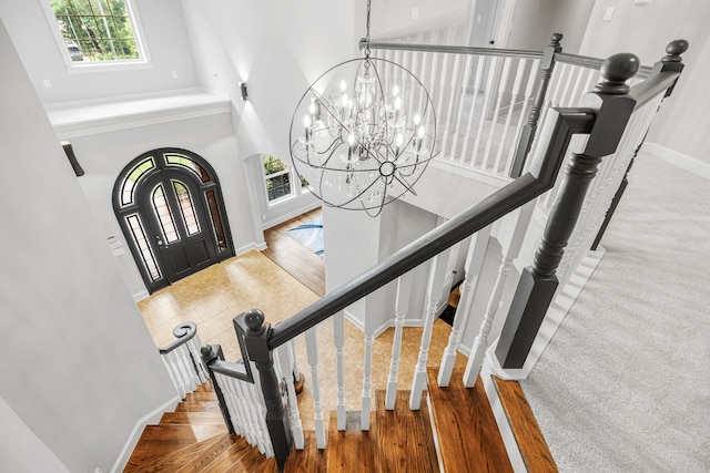 stairs featuring an inviting chandelier, a high ceiling, and carpet