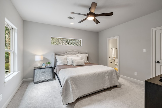 bedroom featuring ceiling fan, ensuite bath, and light carpet