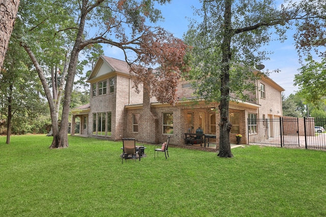 back of house featuring a lawn and a patio