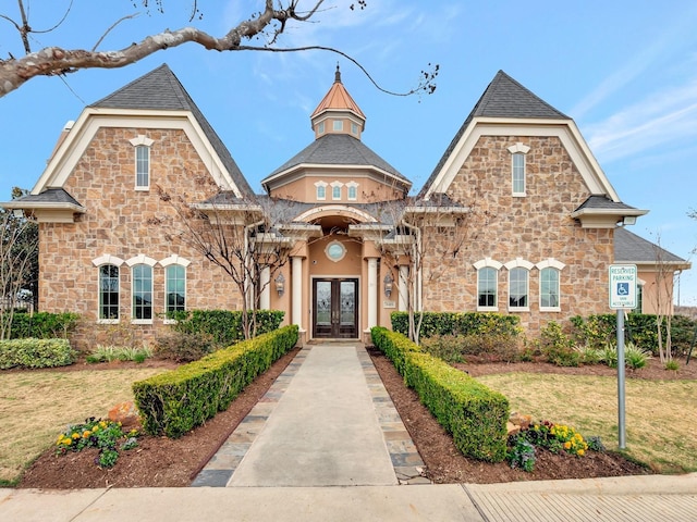 view of front of home with a front lawn and french doors