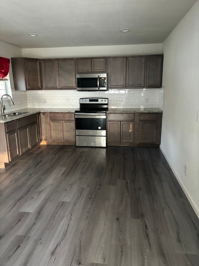 kitchen with sink, stainless steel appliances, and hardwood / wood-style flooring