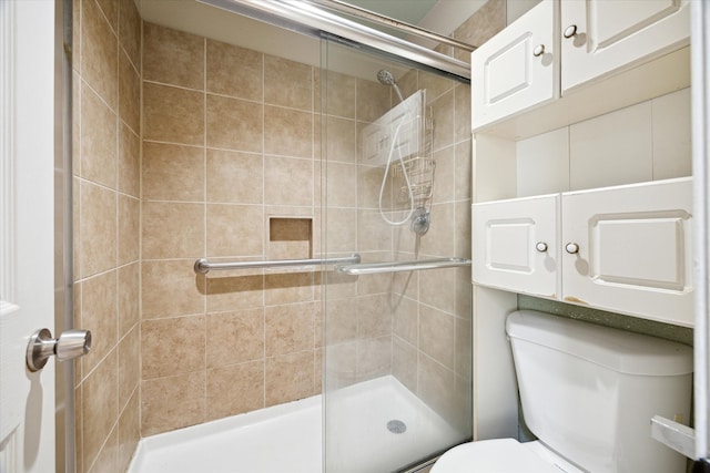 bathroom featuring toilet and an enclosed shower