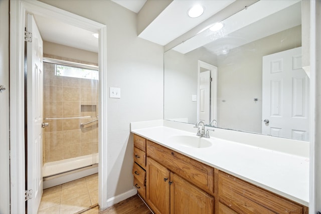 bathroom featuring tile patterned floors, a shower with door, and vanity