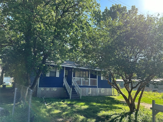 view of front of home with a porch and a front yard